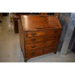 A 19th Century oak bureau, having four long drawers and bracket feet