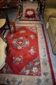 Two red ground carpet rugs or runners having floral decoration