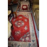 Two red ground carpet rugs or runners having floral decoration