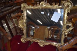 A Chippendale style period mirror with elaborately carved gilt and gesso frame with silver backed