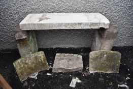 A garden bench having sand stone uprights with RAF military headstone as seat and similar carved