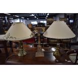 Two brass bodied table lamps and a candle stem