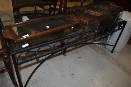 A wrought iron framed coffee table having glass top