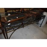 A wrought iron framed coffee table having glass top