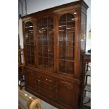 A reproduction oak bookcase, of nice quality having glazed top over drawer and cupboard base,