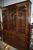 A reproduction oak bookcase, of nice quality having glazed top over drawer and cupboard base,