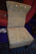 A vintage nursing chair with moquette style upholstery on stained frame