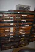 An industrial printers type set drawer unit with 19 letterpress drawers of various ages all with