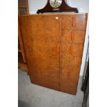 A 1930s figured walnut tallboy having phenolic style handles and fitments