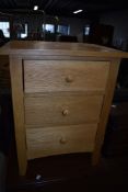 A modern golden oak effect three drawer chest