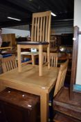 A modern golden oak fold over dining table and set of four chairs