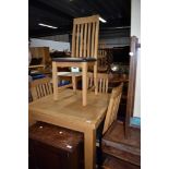 A modern golden oak fold over dining table and set of four chairs