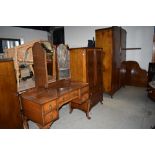 A Edwardian bedroom suit comprising of wardrobe tall boy dressing table and bed head all in burr
