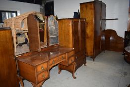 A Edwardian bedroom suit comprising of wardrobe tall boy dressing table and bed head all in burr