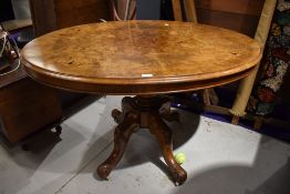 A 19th Century walnut and inlaid oval snap top pedestal table on turned column and quadruple foliate