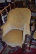 An early Victorian carved framed large salon chair having button back upholstery