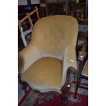 An early Victorian carved framed large salon chair having button back upholstery