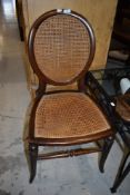 A Victorian bed room or salon chair having balloon back and woven fibre seat