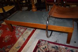 A mid century teak framed long coffee table having stone slate cut top