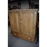 An antique stripped yellow pine cloak cupboard with under drawer and ceramic handles