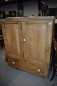 An antique stripped yellow pine cloak cupboard with under drawer and ceramic handles