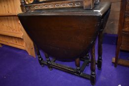 A Priory or Dark Ercol style drop leaf dining table