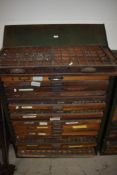 An industrial printers type set drawer unit with 18 letterpress drawers of various ages all with