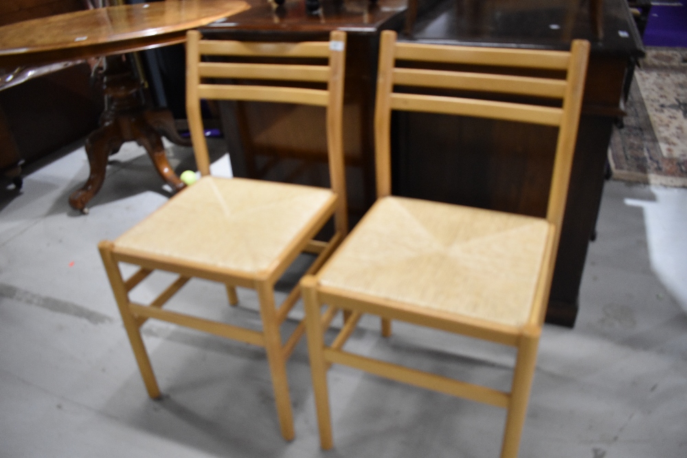 A pair of beech framed kitchen chairs having synthetic 'rush' seats