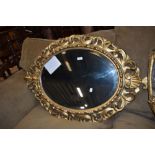 A late 18th century oval shaped mirror having acanthus leaf carved gilt and gesso frame work with