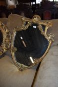 A regency shield shaped mirror having elaborate carved gilt and gesso frame work with silvered