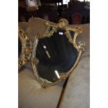 A regency shield shaped mirror having elaborate carved gilt and gesso frame work with silvered