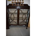 An early 20th Century mahogany bookcase/display cabinet having ball and claw feet