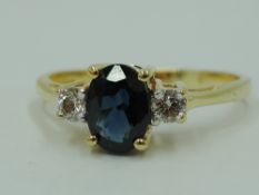 A three stone sapphire and diamond dress ring having an oval sapphire, approx 0.5ct flanked by two