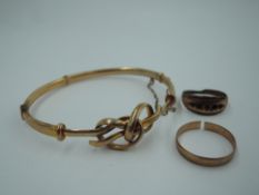 Three pieces of damaged 9ct gold jewellery including wedding band, hinged bangle with knot