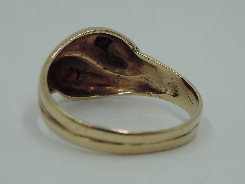 A 9ct gold entwined snake ring having inset garnet eyes, size V & approx 4.3g - Image 3 of 3