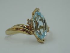 A marquise cut aqua marine and diamond chip dress ring having moulded off set shoulders to a