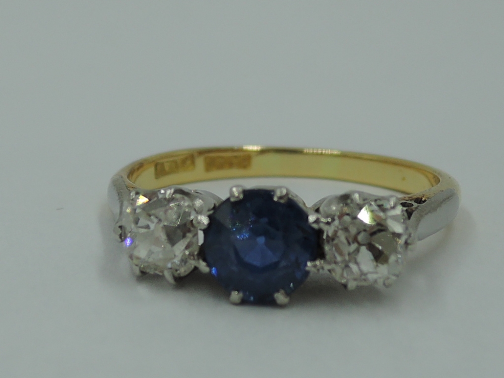A lady's old cut sapphire and diamond three stone ring, sapphire approx .75ct and total diamonds