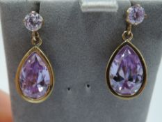 A pair of 9ct gold stud earrings having amethyst coloured drops in collared mounts, approx 3.6g