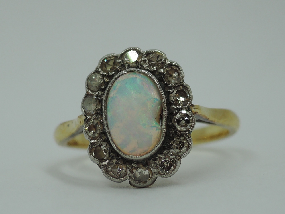 An opal and diamond cluster in a collared basket mount on a yellow metal loop stamped 18ct, size P & - Image 3 of 4