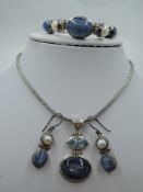 A silver three piece artisan style set comprising necklace, bracelet & earrings having blue