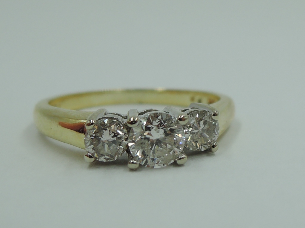 A diamond trilogy dress ring, total approx 1ct in a claw set stepped mount on a yellow metal loop
