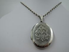A late 19th/early 20th century white metal locket with applique monogram to front, no marks tested