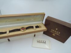 A lady's 1980's Gucci quartz wrist watch having stripe face and Roman numeral bezel dial to gold