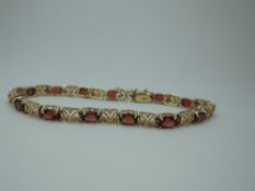 An American 14ct gold articulated bracelet by Baith having fourteen garnets interspersed by gold