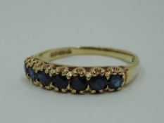 A seven stone sapphire half eternity ring in a claw set mount on a 9ct gold loop, size Q & 2.7g