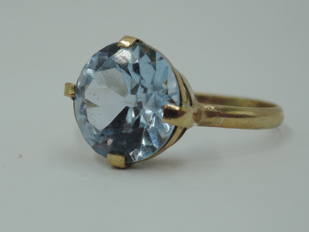 A blue topaz style solitaire ring having four claw set mount on a yellow metal loop stamped 9ct, - Image 3 of 3