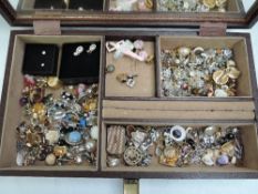 A jewellery box containing a large selection of stud and clip earrings of various forms including
