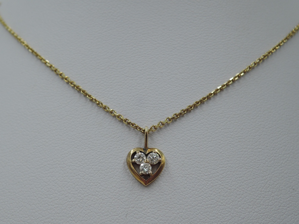 A yellow metal heart pendant having a trio of small diamonds in an open mount on a yellow metal - Image 2 of 2