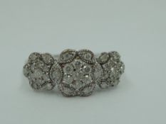 A diamond chip triple cluster ring in pave setting, total approx 0.5ct on a 9ct white gold loop,