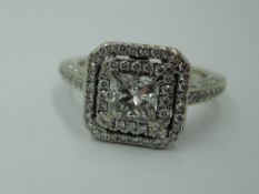 A princess cut diamond, approx 0.5ct ring in a diamond set halo surround to diamond set shoulders on